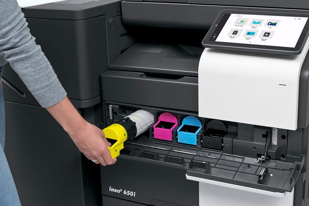 image of a person changing the ink in an ineo printer